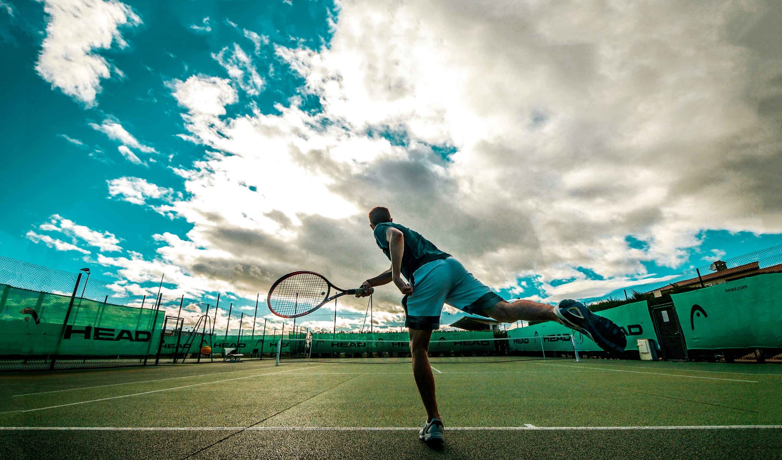 Foto eines Tennisspielers beim Aufschlag, von hinten aufgenommen